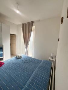 a bedroom with a blue bed and a window at Egidio's House Casa Vacanze Portixeddu in Portixeddu