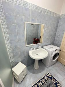 a bathroom with a sink and a washing machine at Egidio's House Casa Vacanze Portixeddu in Portixeddu