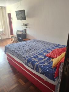 a bedroom with a bed with a blue comforter at Apartamento Teresópolis alto in Teresópolis