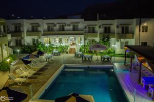a swimming pool in front of a hotel at night at Tsambika Sun Hotel in Archangelos