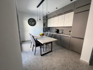 a kitchen with a table and chairs and a clock on the wall at Villa Matea pool house in Zadar