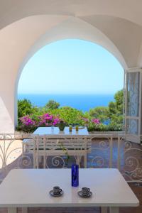 a patio with tables and a view of the ocean at Il Carrubo Capri in Anacapri