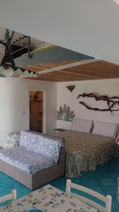 a bedroom with a bed and a couch at Le Case dei Pescatori - Mare Blu in Ponza