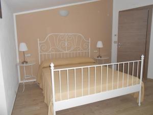 ドルガーリにあるCasa Vacanze Villa Rosettaのベッドルーム1室(白いベッド1台、テーブル2台付)