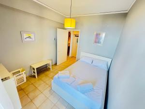 a small bedroom with a bed and a kitchen at Blue Pearl Chios apartment in Chios