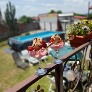 due bicchieri di gelato e fragole su un balcone di Vila Eric LG a Budeşti Altre 13 foto