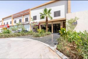 een gebouw met een palmboom ervoor bij Towlan Alrayan in Riyad