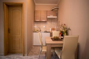 a kitchen with a wooden table and chairs and a kitchen with white appliances at Apartments Ratkovic in Trebinje