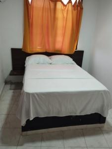 un lit avec un rideau orange dessus dans l'établissement Hotel Quinta Avenida S M, à Santa Marta