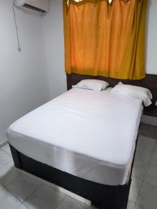 un lit assis dans une pièce avec une fenêtre dans l'établissement Hotel Quinta Avenida S M, à Santa Marta