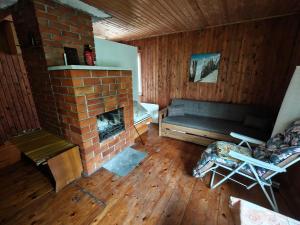 a living room with a brick fireplace and a couch at Retrohõnguline suvila saunaga Laulasmaal, privaatne puhkus mere lähedal in Laulasmaa +18 photos