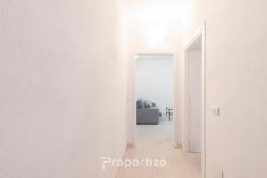 a hallway with white walls and an open door at Lumìa - by Propertize in Dorgali