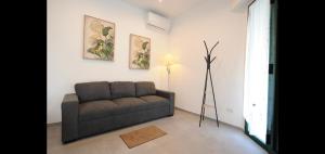 a living room with a couch and a floor lamp at Appartamento Carducci 213 in Marina di Pietrasanta