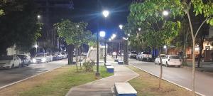 een stadsstraat 's nachts met auto's geparkeerd bij Amador Lucero apart II in San Miguel de Tucumán