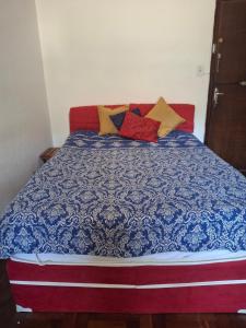 a bed with colorful pillows on top of it at Apartamento Teresópolis alto in Teresópolis +37 photos