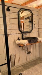 a bathroom with a mirror and a shelf with a sink at Mesteceni Glamping in Nistoreşti