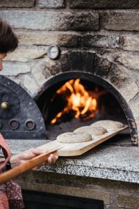 Een vrouw kookt brood in een bakstenen oven. bij Farm apartment I neni in Lovara