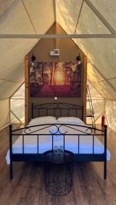a bedroom in a tent with a bed in it at Mesteceni Glamping in Nistoreşti