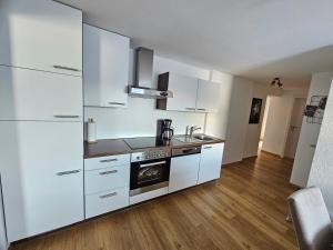 eine Küche mit weißen Schränken und einem Herd in der Unterkunft Ferienwohnung Flir in Jerzens + 2 Fotos