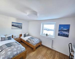 ein Schlafzimmer mit zwei Betten und einem Fenster in der Unterkunft Ferienwohnung Flir in Jerzens
