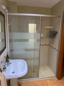 a shower with a glass door next to a sink at Pensión Dani in Casinos +23 photos