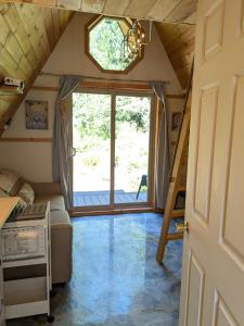 パウエル・リバーにあるTree Ring Cabin on 33 Acresの大きな窓と階段のある小さな家