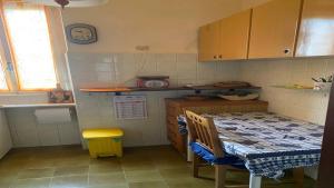 a small kitchen with a table and a yellow stool at La Tua Pausa Torinese in Turin