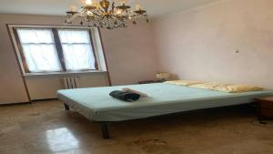 a bedroom with a large bed with a chandelier at La Tua Pausa Torinese in Turin
