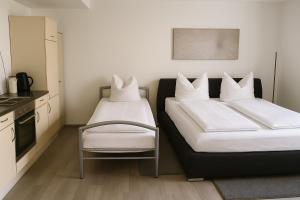 two beds in a kitchen with white pillows on them at Ferienwohnung Panoramablick in Sinsheim