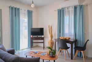 a living room with a couch and a table with a television at Kythira echoes stay - Lithari in Kythira