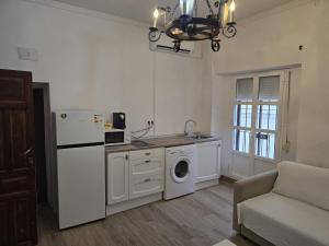 a kitchen with a white refrigerator and a washing machine at Apartamentos Arquillo de Rota in Sanlúcar de Barrameda