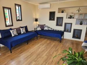 a living room with blue couches and wooden floors at G and A House in Póros Kefalonias
