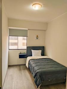 a bedroom with a large bed and a window at Departamento amplio y céntrico-Terrazas in San Antonio