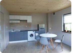 a kitchen with a table and a washing machine at Domki pod Dębem 1 in Kołczewo