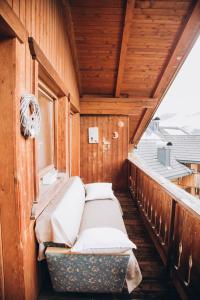een bed in een houten kamer met een raam bij Farm apartment I neni in Lovara +24 foto's