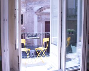 a view of a balcony with yellow chairs and a table at San Carlo Cuore di Palermo in Palermo