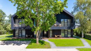 ein modernes Haus mit schwarzer Fassade in der Unterkunft TOPOLIŲ Apartamentai in Palanga