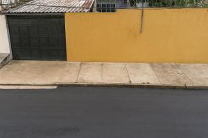 a sidewalk with a yellow wall and a garage at Casarão COP30 in Belém