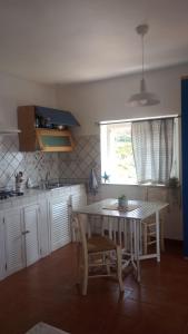a kitchen with a table and chairs and a window at Le Case dei Pescatori - Casetta Faraglioni in Ponza +13 photos
