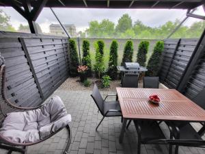 a patio with a table and chairs and a grill at Lipowy Zakątek - domki blisko Energylandii i stacji PKP w Zatorze in Zator
