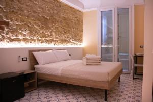 a bedroom with a bed and a wall at San Carlo Cuore di Palermo in Palermo