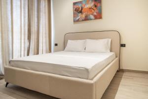 Una cama blanca en una habitación con en Palm Suites Apartments, en Vlorë