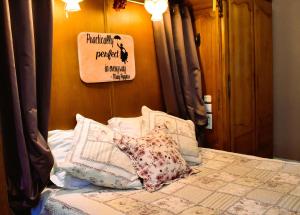 a bedroom with a bed with pillows and a sign on the wall at Suivez Le Lapin Blanc-BB Chambres d'Hôtes in Saint-Valery-sur-Somme
