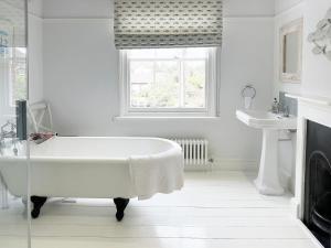 ein weißes Badezimmer mit Badewanne und Waschbecken in der Unterkunft Lighthouse View by The Suffolk Cottage Collection in Southwold + 33 Fotos