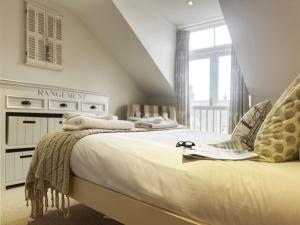 ein Schlafzimmer mit einem Bett mit Brille drauf in der Unterkunft Lighthouse View by The Suffolk Cottage Collection in Southwold
