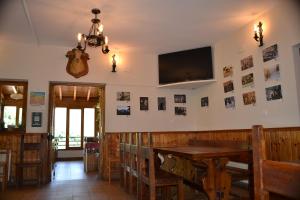 a dining room with a table and a tv on the wall at Taberna de Tresviso in Tresviso