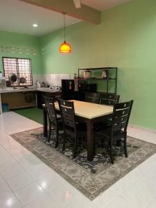 a dining room table and chairs in a kitchen at Homestay Taman Delima Paka in Kampong Gong Gemia
