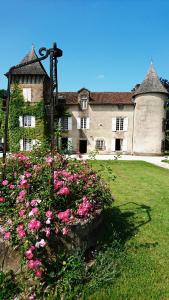 a large building with pink flowers in front of it at Pierre Deluen Domaine de la Grange de Quaire in Chassenon