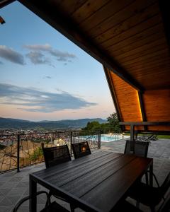 a wooden table on the balcony of a house at Nale Luxury Chalet in Bratunac