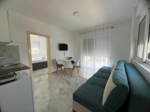 a living room with a blue couch and a table at Noara Apartments Modern Stay Near Beach Free Parking Ideal for Families and Groups in Donji Štoj +15 photos